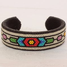 a black and white beaded bracelet with multicolored beads on it's side