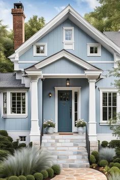 a blue house with white trim on the front door and steps leading up to it