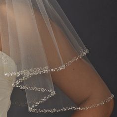 a woman wearing a wedding veil with beaded trim