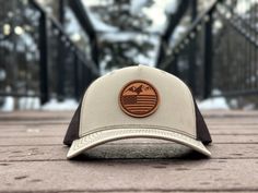 Elevate your style with our unique Mountain Flag leather patch hat, featuring a stunning design that combines mountains and the American flag. The Mountain Flag design is perfect for outdoor enthusiasts and patriots alike, adding a touch of rugged charm to your look. Available on the Richardson 112 FP, a five-panel hat that features a seamless design without a seam down the center of the face, this hat offers a comfortable and stylish fit. The Mountain Flag design is available in multiple colors Outdoor Snapback Hat With Flat Bill Made In Usa, Curved Brim Baseball Cap Made In Usa For Outdoor, Outdoor Baseball Cap With Curved Brim Made In Usa, Outdoor Baseball Cap Made In Usa With Curved Brim, Outdoor Curved Brim Baseball Cap Made In Usa, Brown Hats With Leather Patch For Outdoor Activities, Adjustable Baseball Cap Made In Usa For Outdoor, Flat Bill Hats Made In Usa For Outdoor, Outdoor Flat Bill Hats Made In Usa