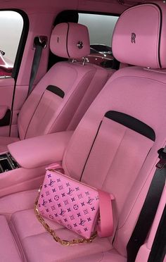 the interior of a car with pink leather and black trims, including a purse