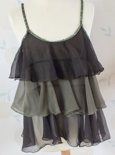 This is a very pretty layered Cami Top in a Chiffon type fabric. Very lightweight and floaty. It is transparent. In Khaki Green and Dark Brown. The straps are made from beading and this continues around the neckline. There is no Brand name apparent. I would say it is a UK 12 - 14. Designed to be worn quite loose. Good condition. Would look lovely with jeans or dressed up with silky trousers or a skirt. Layered Cami, Frill Tops, Khaki Green, Cami Top, Cami Tops, Chiffon Tops, Womens Clothing Tops, Camisole Top