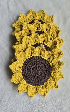 These are beautiful sunflower coasters that will brighten your day with their lovely color. Handmade with love, these coasters feature vibrant yellow petals and a rich brown center. Perfect for protecting any surface from your drinks. these coasters are both functional and decorative.  They are made from durable cotton yarn. The center is approximately 3" in width and the coaster is around 5 1/2" in total.  The price is for a set of 4. If you have any questions, please let me know. Crochet Sunflower Coaster, Sunflower Coaster, Sunflower Coasters, Coasters Crochet, Yellow Petals, Crochet Sunflower, Crochet Coasters, Lovely Colors, Brighten Your Day