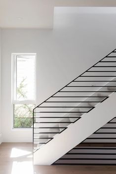 an empty room with a stair case next to a window