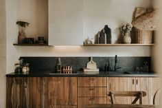 a kitchen with wooden cabinets and shelves filled with bottles on top of them, along with other items