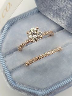 two diamond rings sitting in a blue velvet box