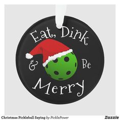 a round ornament that says eat, drink and be merry with a green bowling ball wearing a santa hat