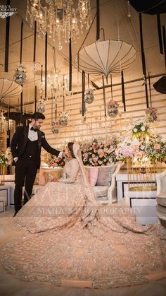 a bride and groom standing in front of chandelier