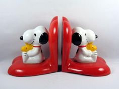 pair of red and white snoopy bookends with black eyes on each side