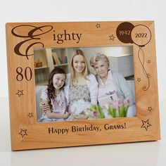 a wooden frame with an image of two women and a child on it that says eighty happy birthday, grannys