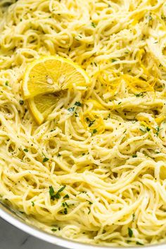 a pan filled with pasta and lemon wedges