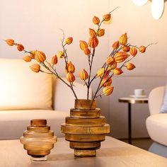 a vase filled with lots of coins sitting on top of a wooden table next to a white couch