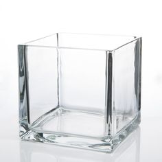 a square glass vase sitting on top of a white table