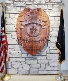 a brick wall with two flags and an emblem on it