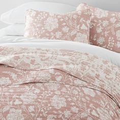 a bed covered in pink and white sheets