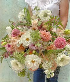 a woman holding a large bouquet of flowers