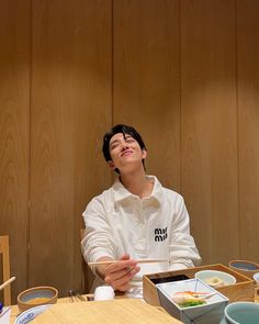 a man sitting at a table with food in front of him and his eyes closed