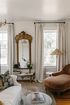 a living room filled with furniture and a large mirror