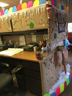 an office decorated for christmas with decorations on the desk and in front of it is a cubicle