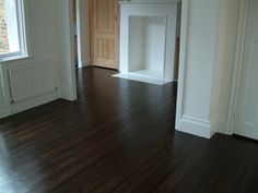 an empty room with hard wood floors and white walls