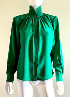 "Gorgeous vintage C1980s sumptuous, butter soft heavy silk long sleeved forest green blouse by Levante, featuring a nehru collar, front and back top pleats, and a front button closure under a hidden button placket. Approximate Measurements:        Chest, Waist, Hips: Up to 48\"; Length: 23\"        Labeled a size 6 Fabric:  100% silk Condition: Excellent, likely unworn, vintage condition." Green Long Sleeve Top For Evening, Green Long Sleeve Blouse For Formal Occasions, Green Silk Tops For Fall, Formal Green Blouse For Fall, Vintage Green Blouse For Party, Vintage Green Formal Tops, Green Long Sleeve Formal Blouse, Green Silk Padded Blouse, Nehru Collar Blouse