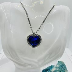 Experience the magic and elegance of the Titanic with our stunning Titanic Medallion Amulet. The bright blue pendant, decorated with sparkling rhinestones, attracts everyone's attention and gives every outfit a touch of glamor and romance. The high-quality silver-plated chain with a length of approx. The height is approx. 55 cm, which can be extended by a further 5 cm, perfectly complements the enchanting medallion. This unique piece of jewelry, reminiscent of the famous Titanic diamonds, will s Party Crystal Rhinestone Heart Pendant Necklace, Jeweled Crystal Rhinestone Pendant Necklace, Jeweled Pendant Rhinestone Necklace, Crystal Rhinestone Jeweled Pendant Necklace, Glamorous Crystal Rhinestone Necklace As Gift, Glamorous Crystal Rhinestone Necklace For Gift, Jeweled Crystal Rhinestone Necklace As Gift, Glamorous Rhinestone Necklace With Diamond Accents As Gift, Royal Blue Crystal Jewelry For Party