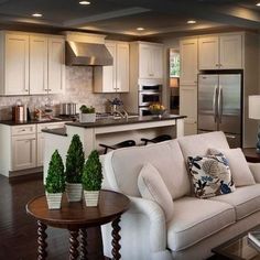 a living room filled with furniture next to a kitchen