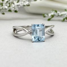 a ring with an aqua blue topazte in the center and a twisted band around it