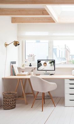 an office with white walls and wooden floors is pictured in this image, there are two desks on the opposite side of the room