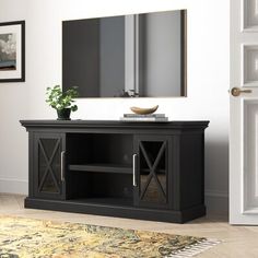 a living room with a large mirror on the wall and a black tv stand in front of it