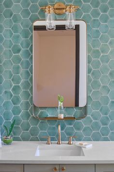 a bathroom sink with a mirror above it and two lights on the wall behind it