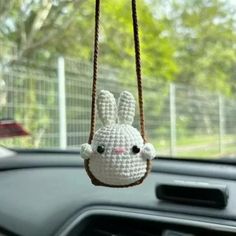 a crocheted bunny hanging from a car dashboard