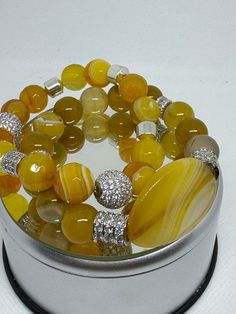 Double strand yellow agate bracelet set with center focal bead. This one has silver bling. Yellow Agate Jewelry With Natural Stones, Adjustable Yellow Crystal Bracelet With Gemstone Beads, Elegant Yellow Polished Beaded Bracelets, Elegant Yellow Beaded Bracelets With Gemstone Beads, Elegant Yellow Stretch Bracelet With Round Beads, Elegant Yellow Bracelets With Gemstone Beads, Yellow Natural Stones Beaded Bracelet, Elegant Yellow Gemstone Beads Bracelets, Elegant Yellow Gemstone Beaded Bracelets