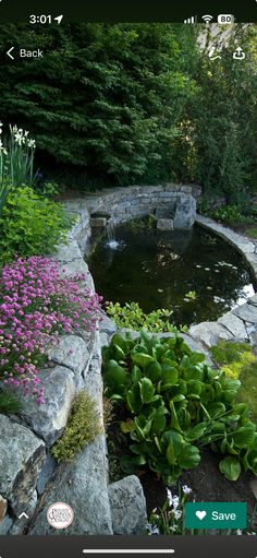 an outdoor pond surrounded by rocks and flowers