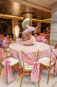 the table is set with pink and white flowers