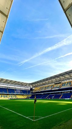 an empty soccer stadium with grass and blue sky in the backgrouds on a sunny day