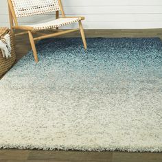 a white and blue rug with a chair in the background