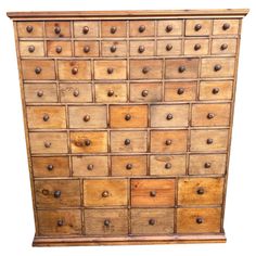 an old wooden dresser with many drawers and knobs on the front, against a white background