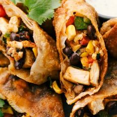 several burritos with black beans, corn and cilantro on a plate