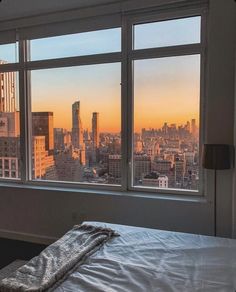 a bedroom with a large window overlooking the city