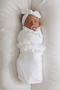 a newborn baby wrapped in a white blanket