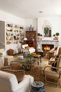 a living room filled with furniture and a fire place in the middle of the room