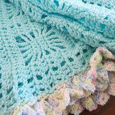 a crocheted blanket laying on top of a wooden table