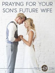 a man and woman standing next to each other in front of a white brick wall