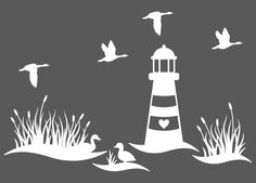 a lighthouse surrounded by seagulls flying over the water with grass and reeds