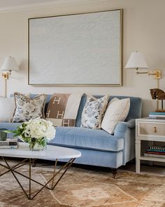 a living room filled with furniture and a painting on the wall above it's couch