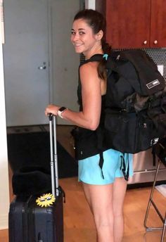 a woman with a backpack and suitcase in a kitchen