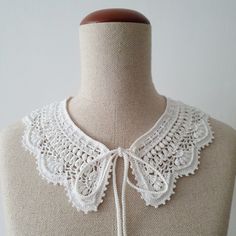 a white crocheted collar on a mannequin