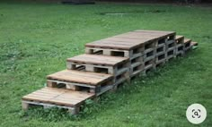 several wooden pallets stacked on top of each other in the grass