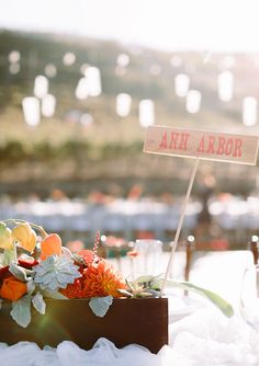 the table is set with flowers and wine glasses for guests to enjoy at an outdoor event